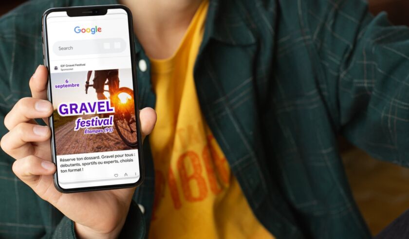 Une personne qui montre son téléphone dans lequel il y a une publicité pour l'événement gravel IDF